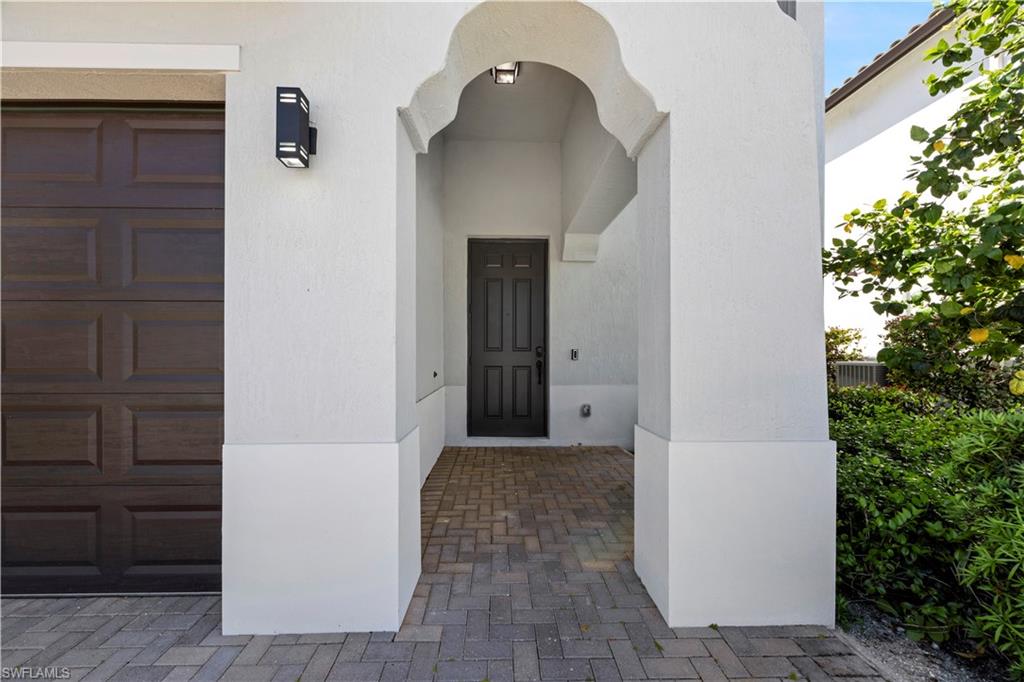9045 Madrid Circle Naples, FL 34104 - Photo 8 of 46 a view of a hallway with wooden floor and entryway