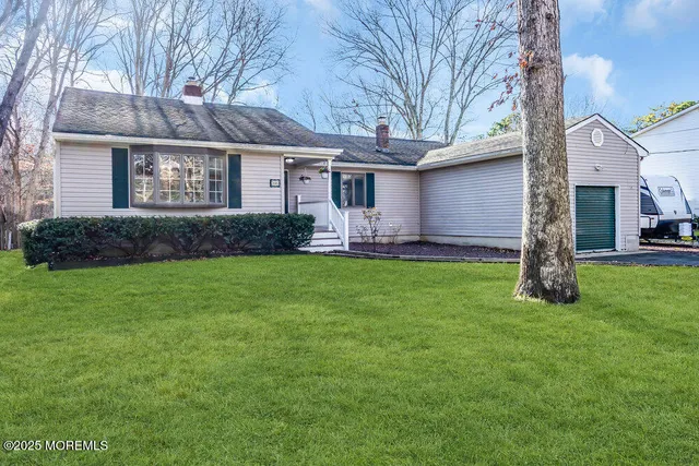 a front view of a house with a garden and yard