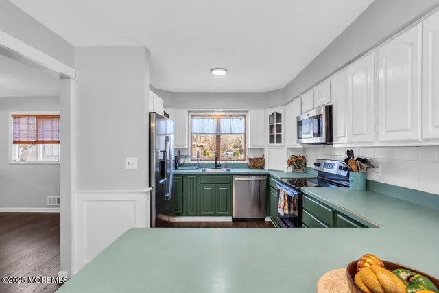 a kitchen with kitchen island a sink stainless steel appliances and cabinets