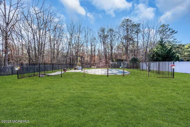 a view of backyard with swimming pool and green space