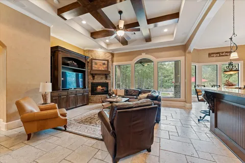 a living room with furniture a flat screen tv and a floor to ceiling window