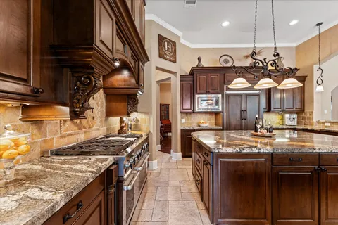a kitchen with stainless steel appliances granite countertop a sink a counter space and a view of living room