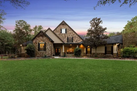 a front view of a house with a garden and trees