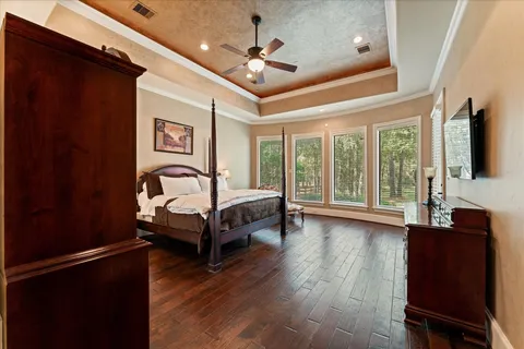 a bedroom with a bed wooden floor and ceiling fan