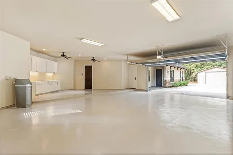 a view of a big room with wooden floor and windows