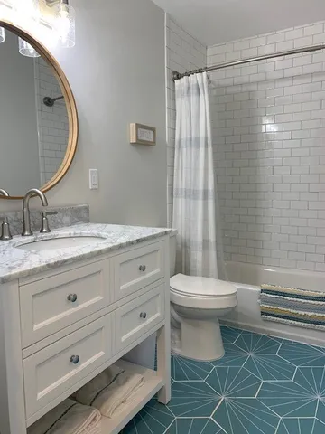 a bathroom with a toilet a sink and mirror