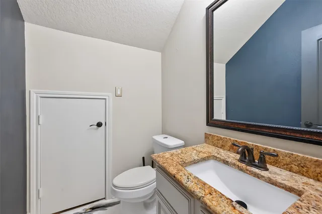 a view of an empty room with wooden floor and a fireplace