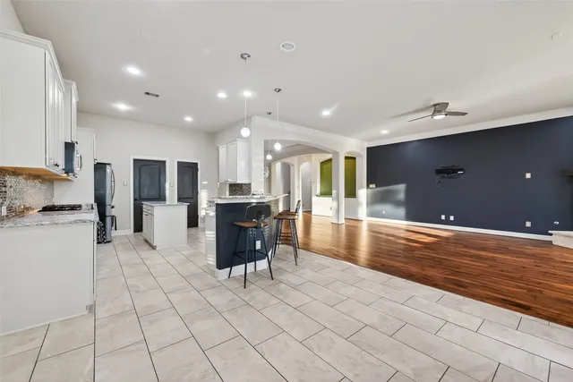 a view of kitchen with kitchen island granite countertop a refrigerator and a sink