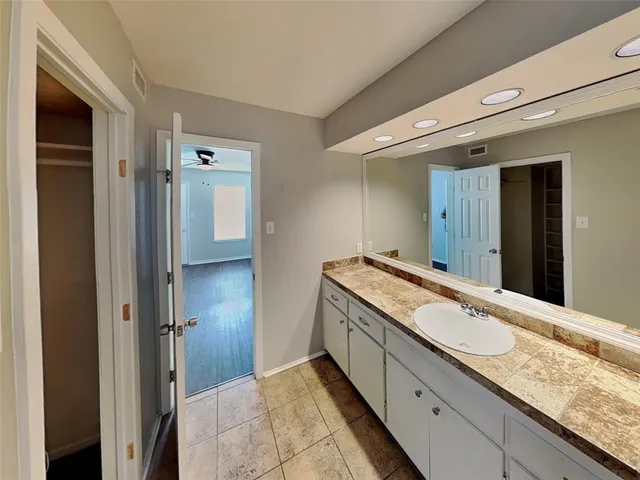 a bathroom with a granite countertop double vanity sink and mirror
