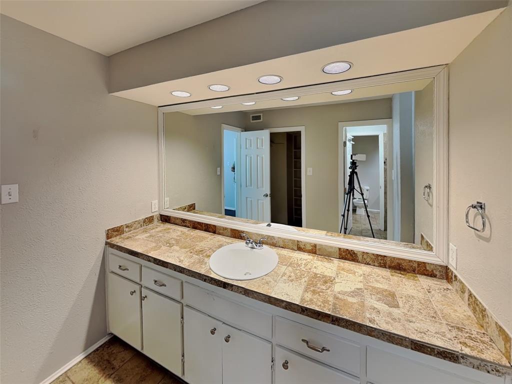 2201 Park Hill Drive Fort Worth, TX 76110 - Photo 12 of 14 a bathroom with a granite countertop sink and a mirror