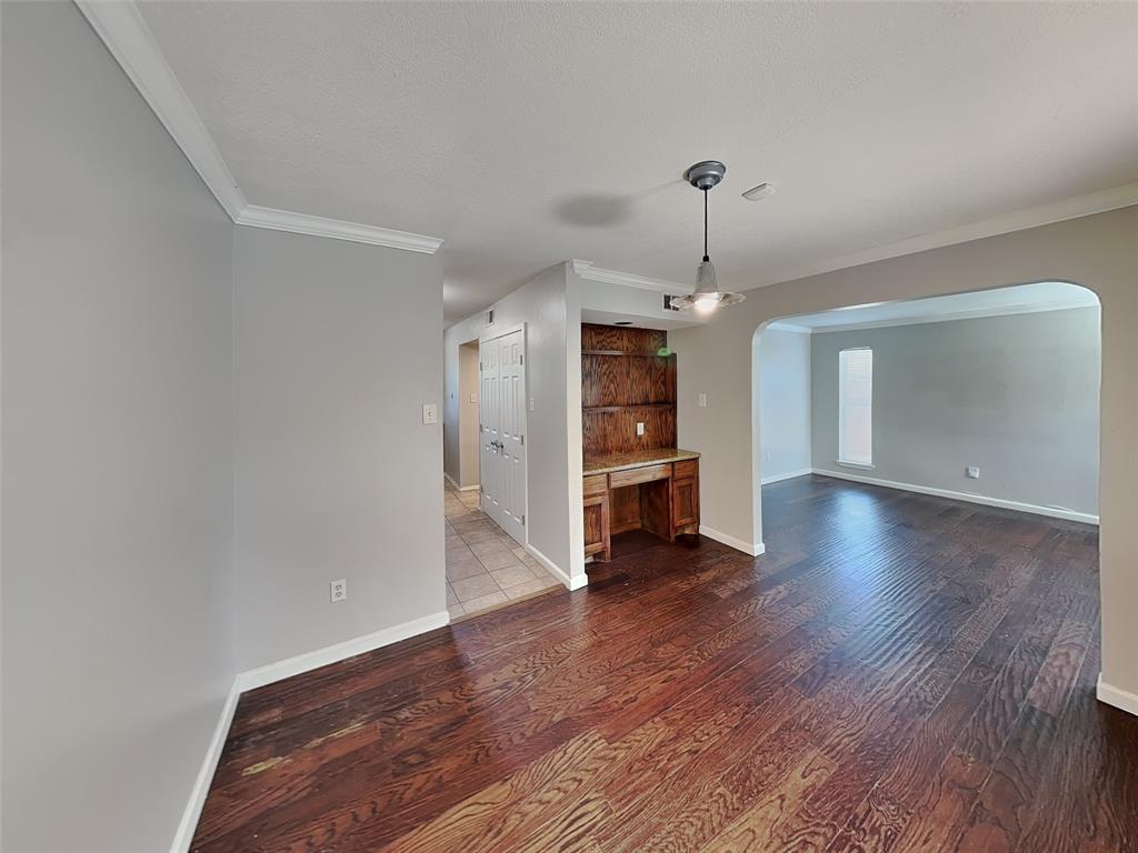2201 Park Hill Drive Fort Worth, TX 76110 - Photo 5 of 14 a view of a room with wooden floor ceiling fan and windows