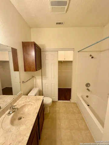 a bathroom with a granite countertop sink and a bathtub