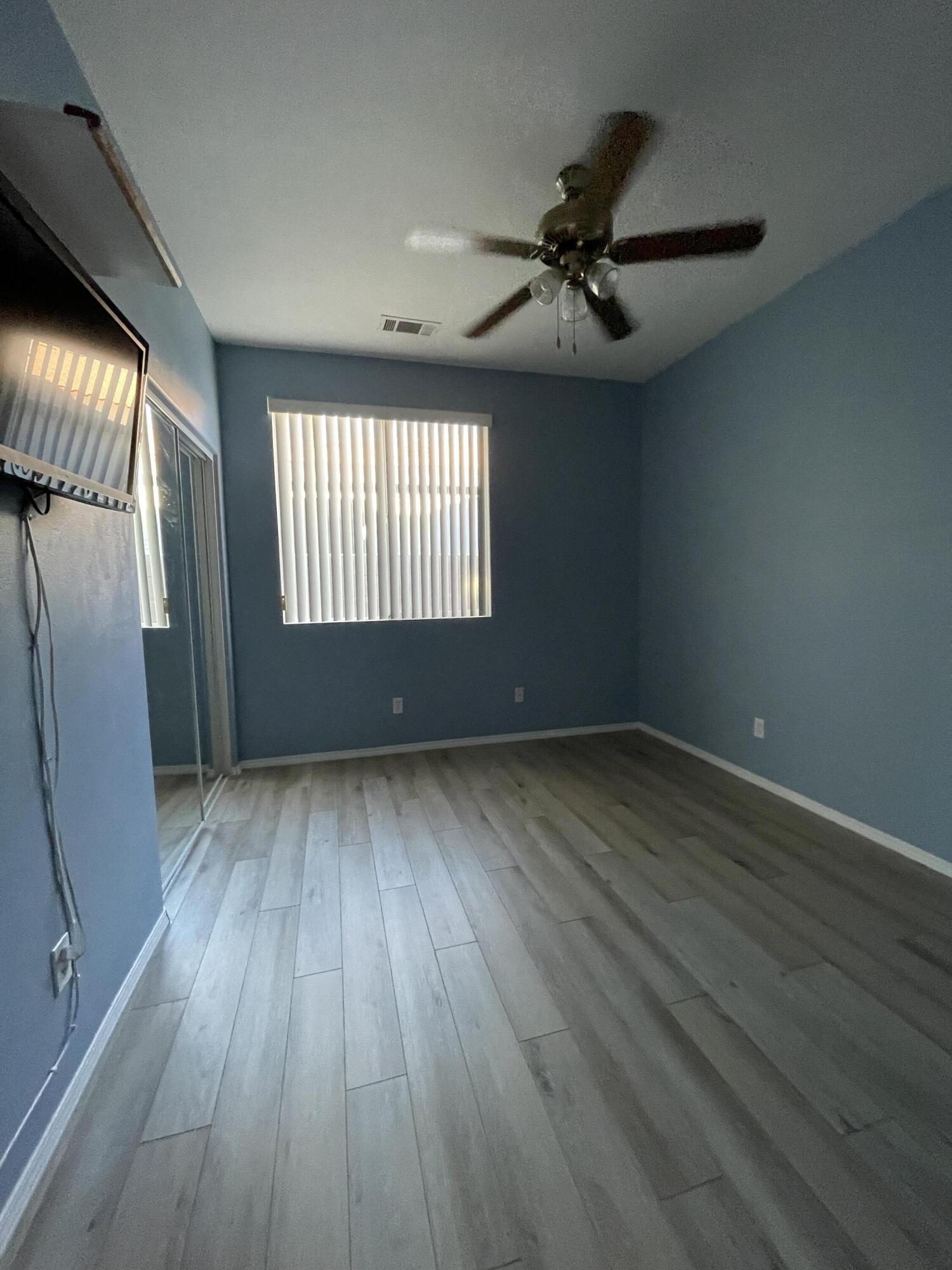 80733 Diamondback Trail Indio, CA 92201 - Photo 11 of 16 an empty room with wooden floor and windows