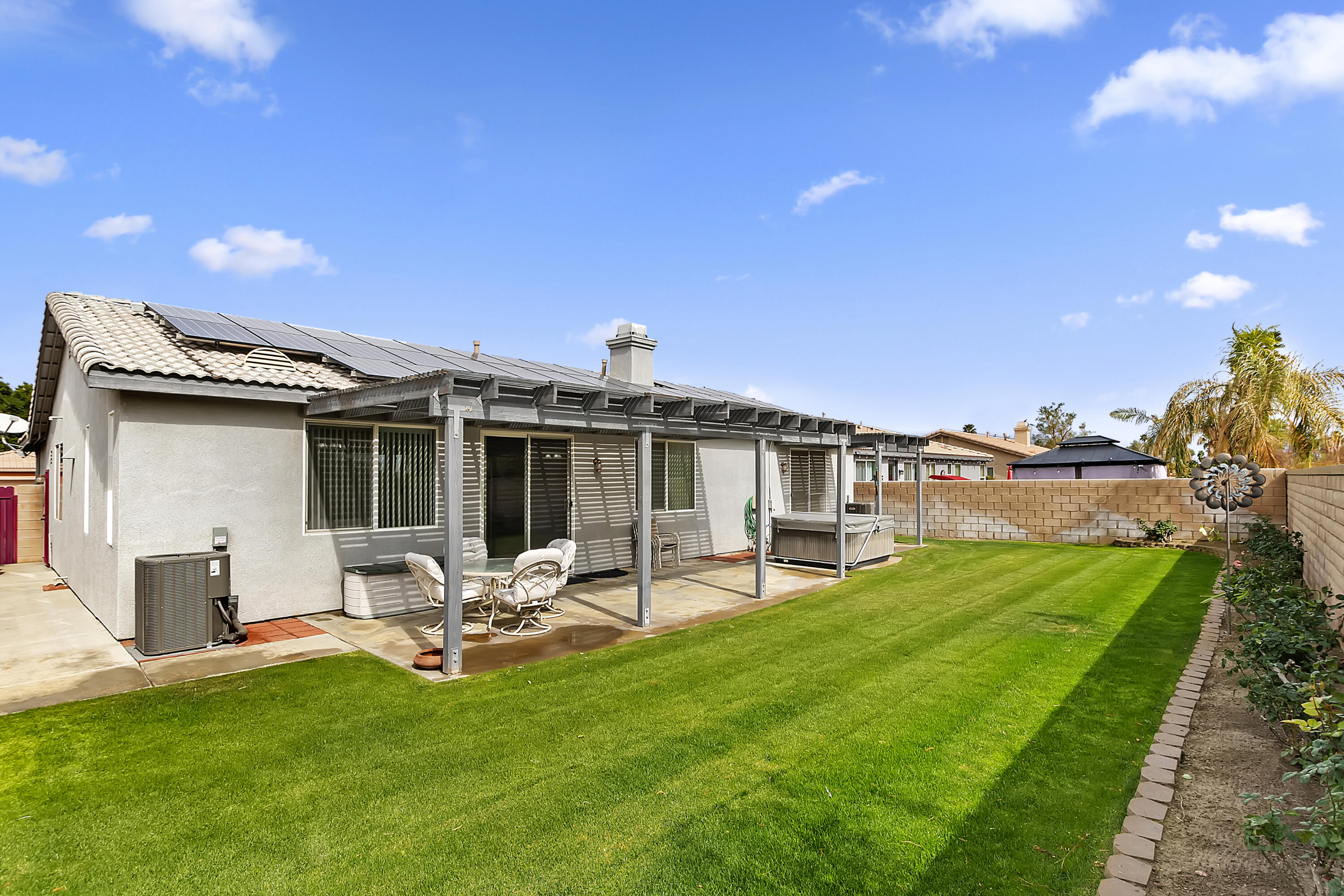 80733 Diamondback Trail Indio, CA 92201 - Photo 14 of 16 a view of a patio with table and chairs with a yard