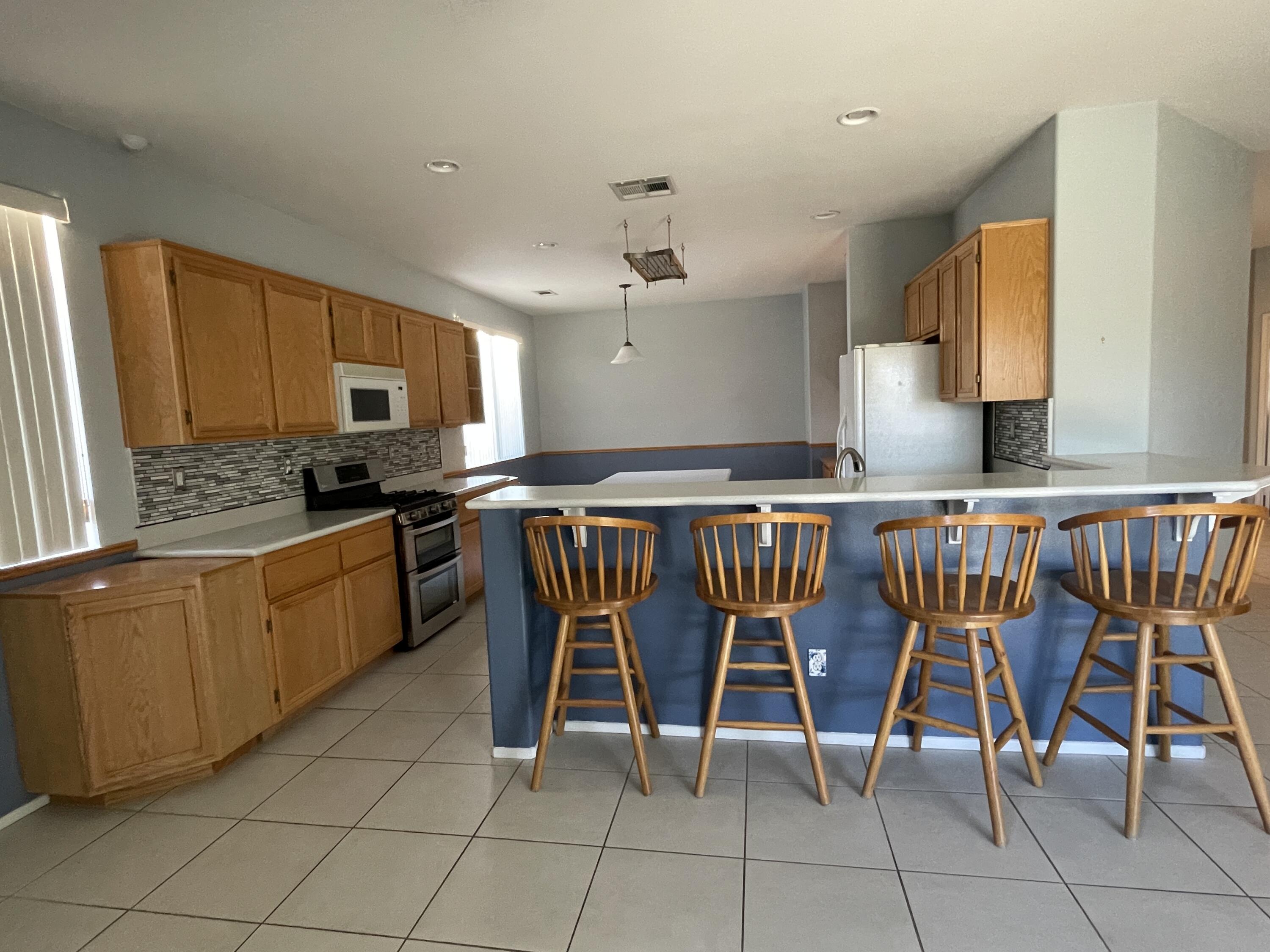 80733 Diamondback Trail Indio, CA 92201 - Photo 6 of 16 a kitchen with stainless steel appliances granite countertop a stove top oven a sink a dining table and chairs