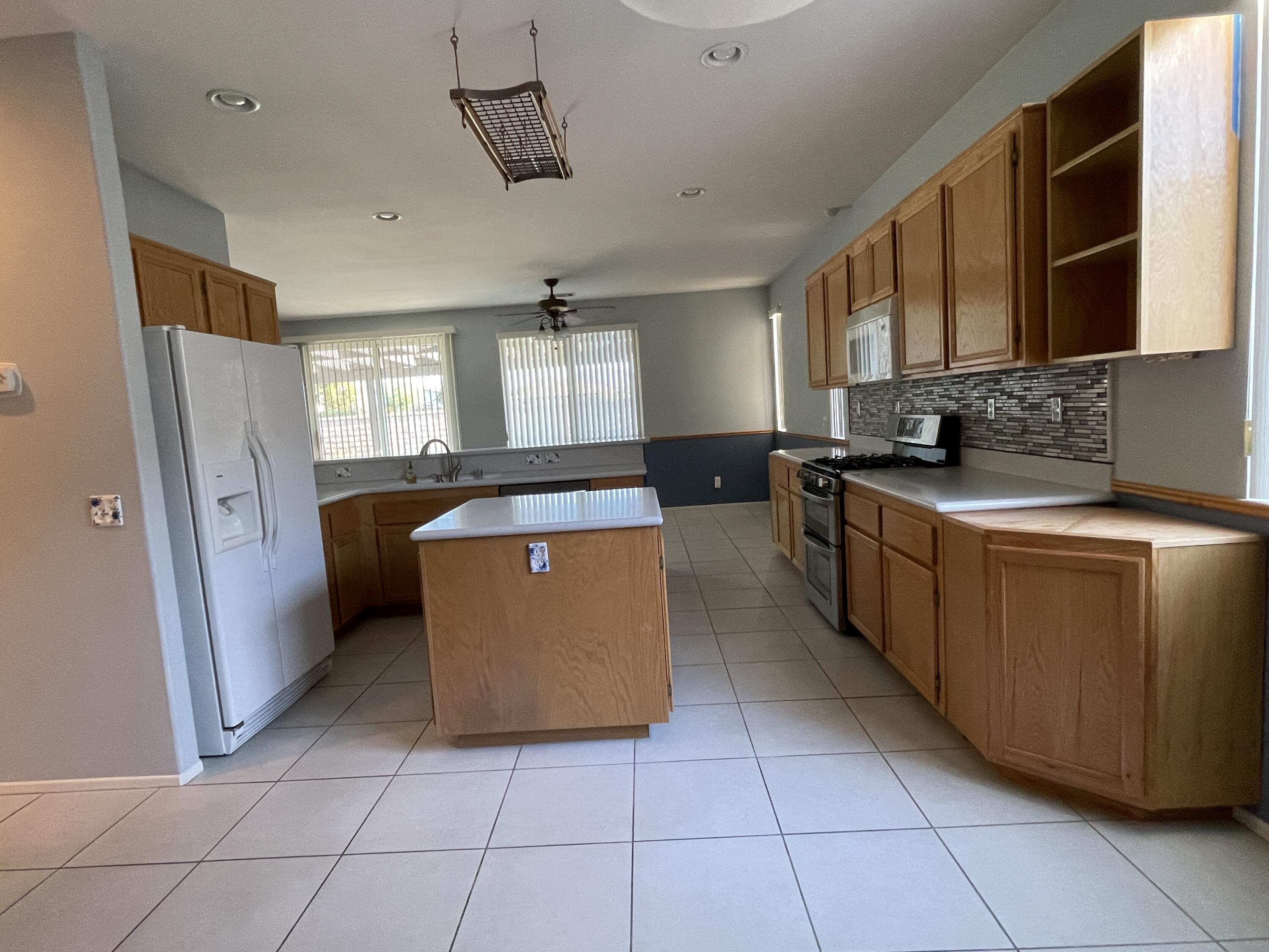 80733 Diamondback Trail Indio, CA 92201 - Photo 7 of 16 a kitchen with stainless steel appliances granite countertop a refrigerator a sink a stove top oven and cabinets