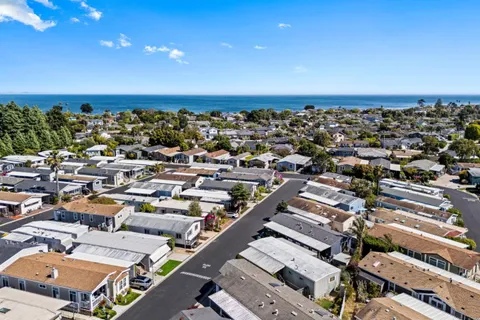 an aerial view of a city with lots of residential buildings and ocean view