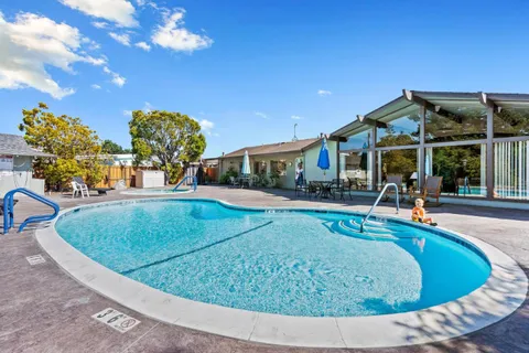 a view of a house with swimming pool and sitting area