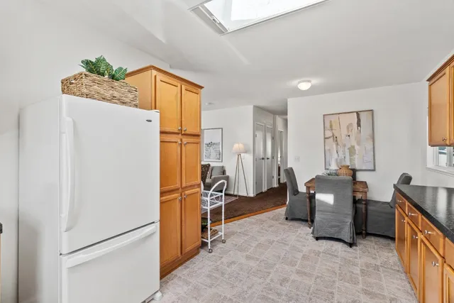 a living room with furniture and a refrigerator