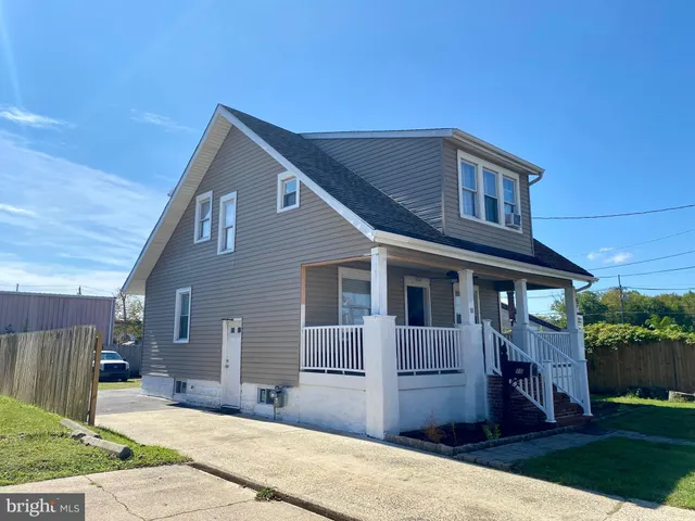 a front view of a house with a yard and potted plants