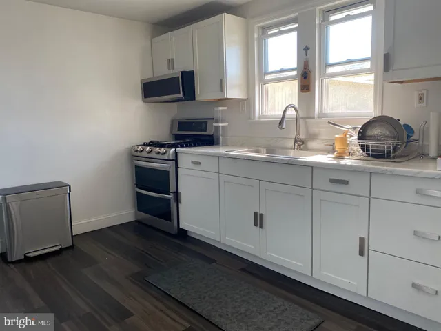 a kitchen with stainless steel appliances granite countertop a sink a stove and a window