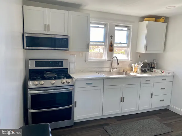 a kitchen with white cabinets and appliances