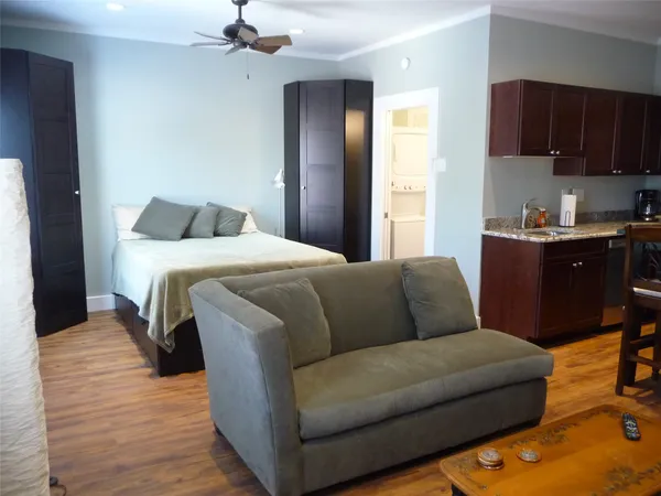 a living room with a bed furniture and a kitchen view