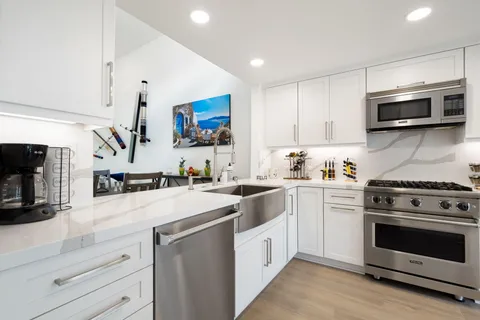 a kitchen with stainless steel appliances granite countertop a stove and a sink
