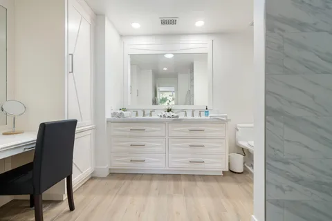 a bathroom with a vanity a sink a mirror and a shower