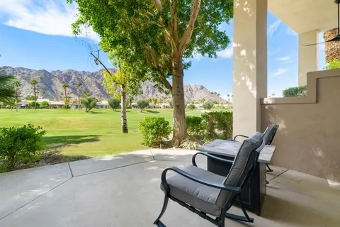 a view of a patio with lawn chairs floor to ceiling window and yard
