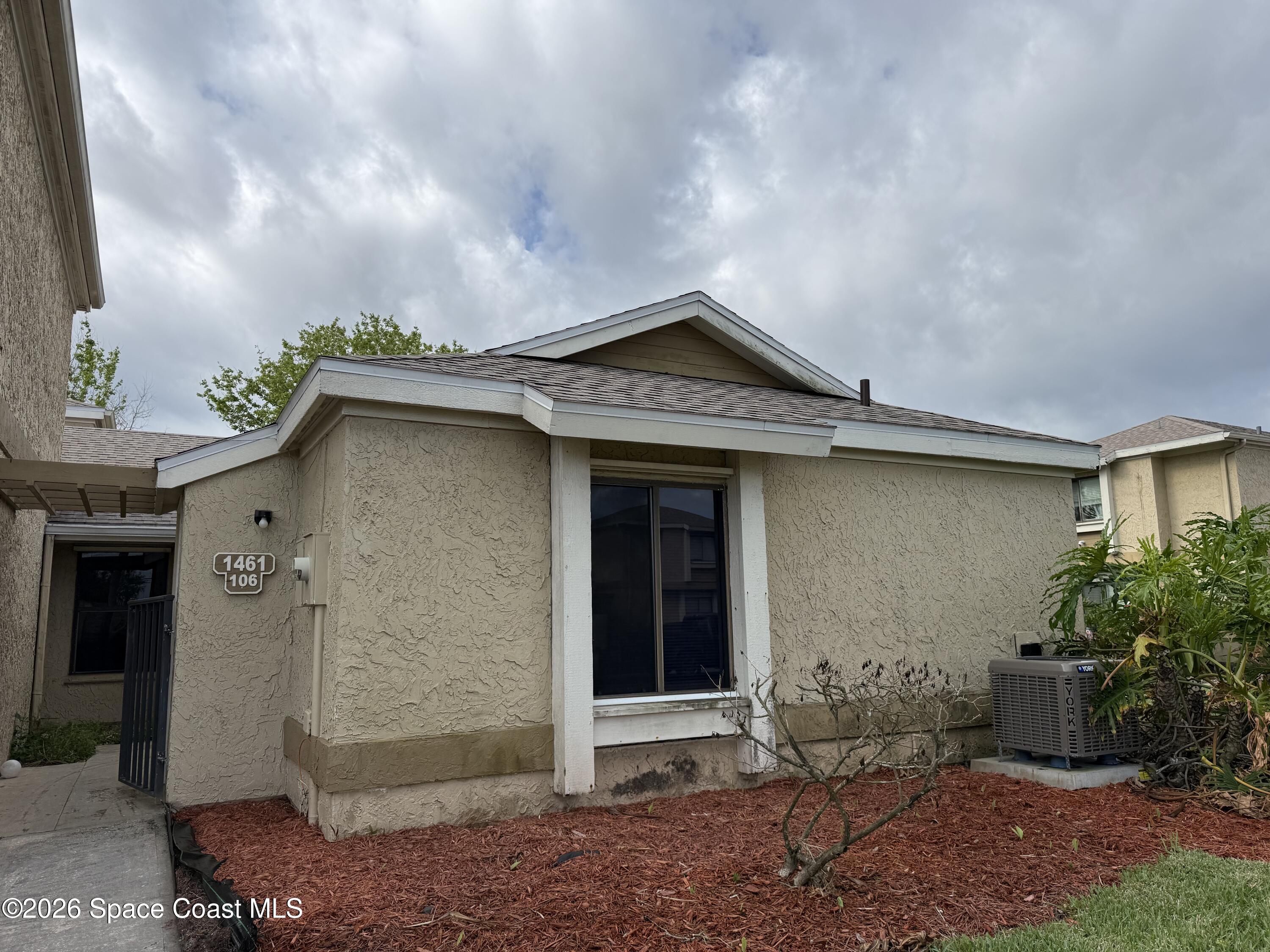 1461 Sheafe Avenue Northeast, Unit 106 Palm Bay, FL 32905 - Photo 1 of 13 a front view of a house with garden