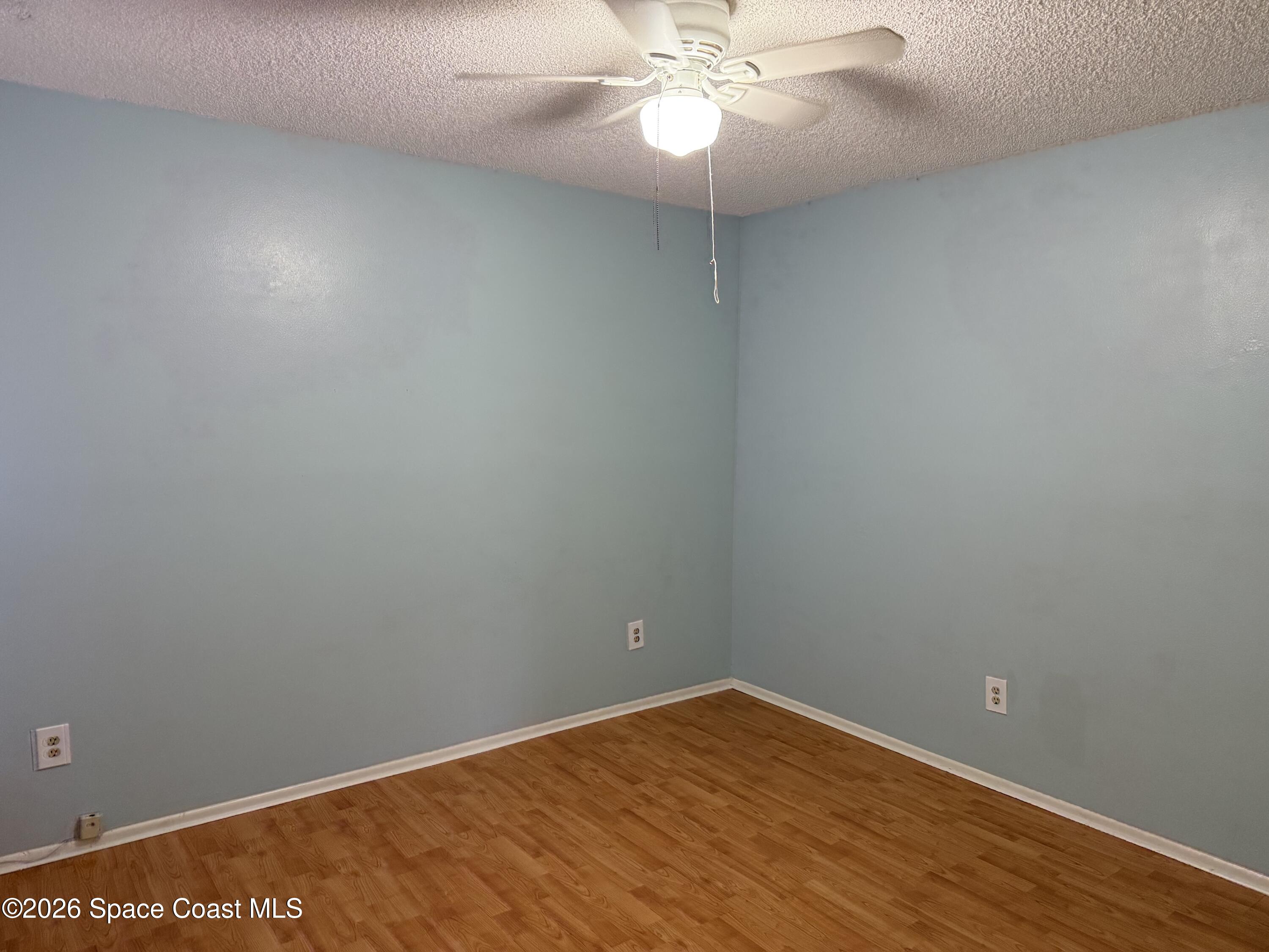 1461 Sheafe Avenue Northeast, Unit 106 Palm Bay, FL 32905 - Photo 12 of 13 en empty room with wooden floor and fan