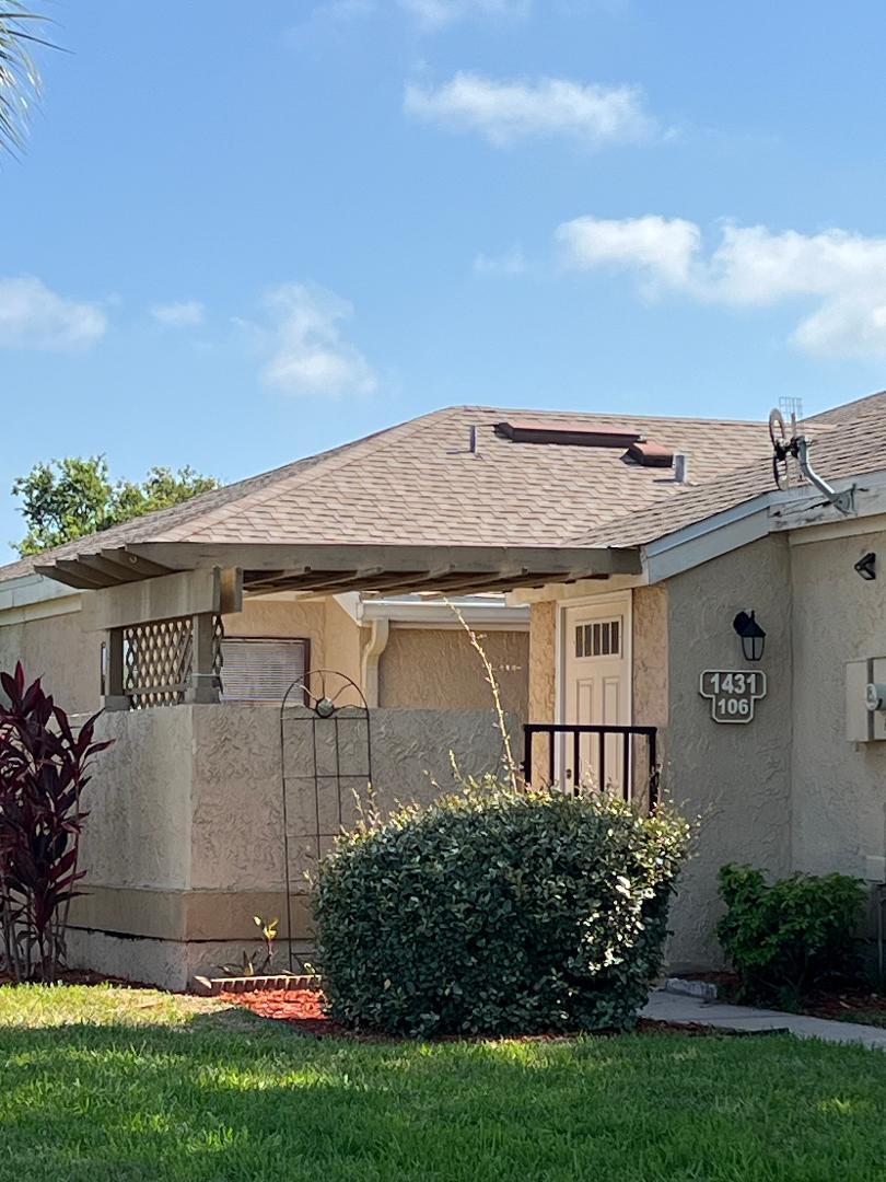 1461 Sheafe Avenue Northeast, Unit 106 Palm Bay, FL 32905 - Photo 2 of 13 front view of a house with a yard