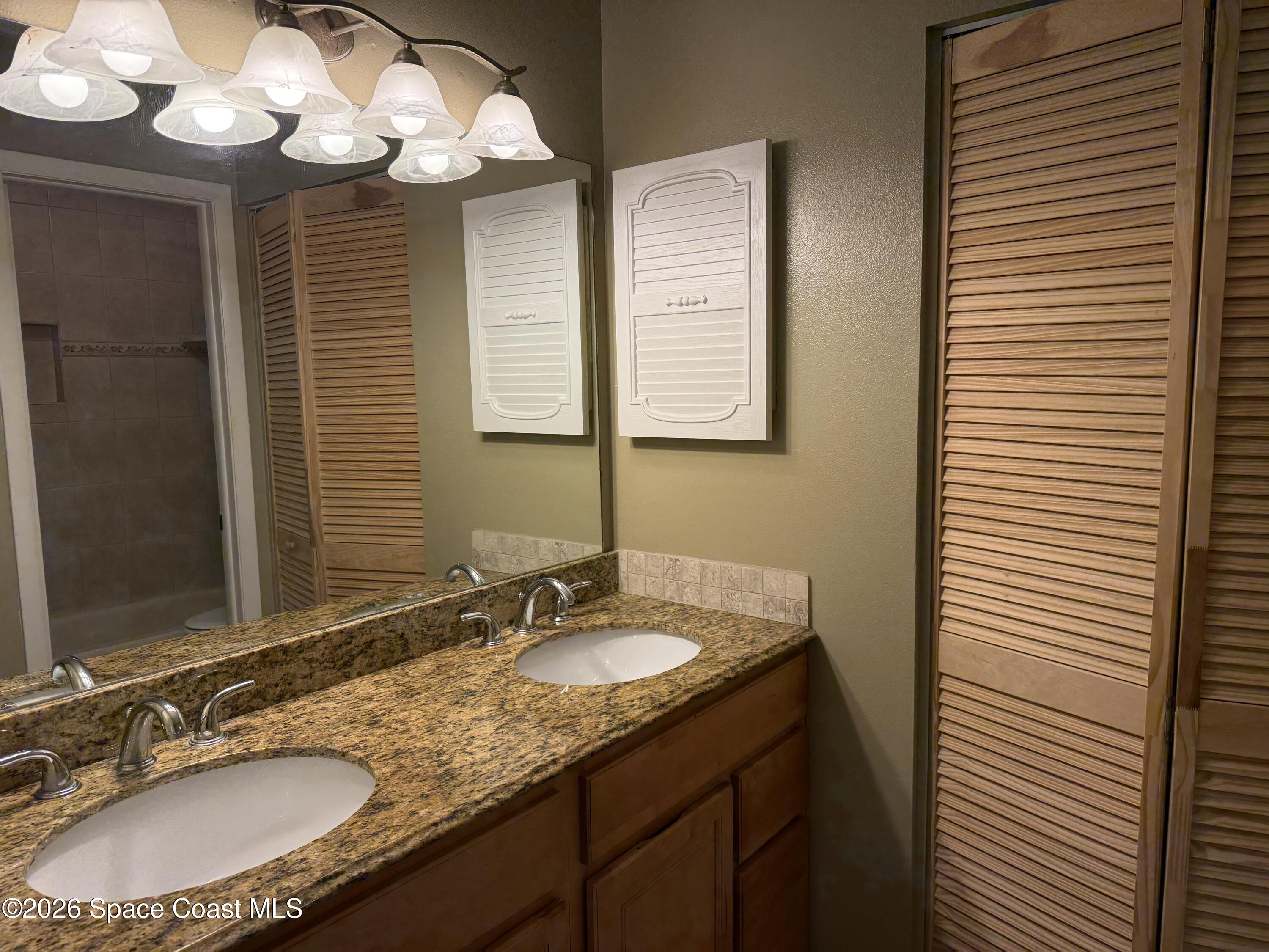 1461 Sheafe Avenue Northeast, Unit 106 Palm Bay, FL 32905 - Photo 10 of 13 a bathroom with a granite countertop sink and a mirror
