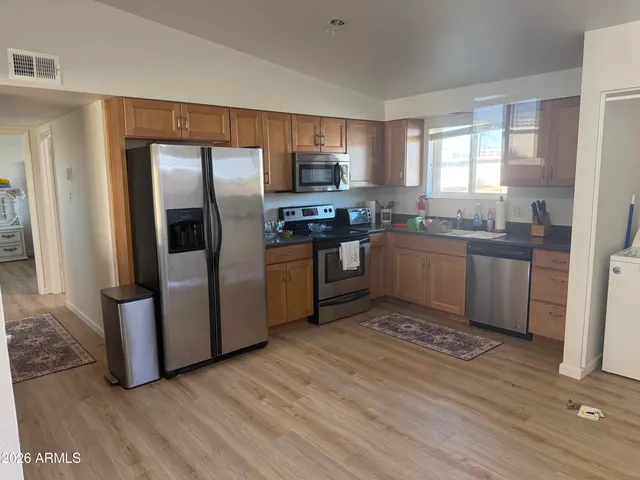 a kitchen with stainless steel appliances granite countertop a stove top oven a sink and dishwasher