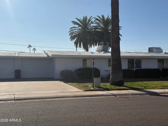 a front view of a house with yard and parking