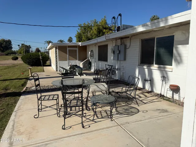 a view of a patio with table and chairs a barbeque with wooden fence