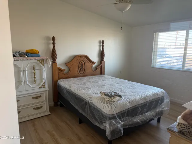 a bedroom with a bed a dresser and window