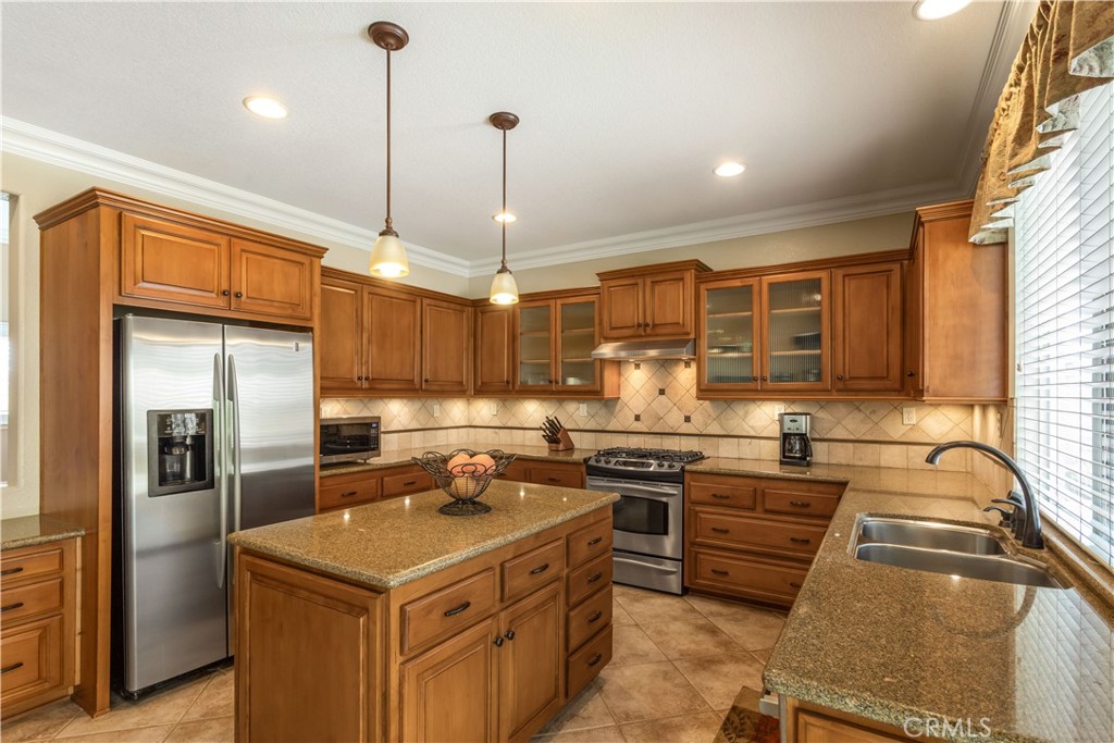 33351 Nicholas Common Temecula, CA 92592 - Photo 11 of 42 a kitchen with stainless steel appliances granite countertop a sink a stove and a refrigerator