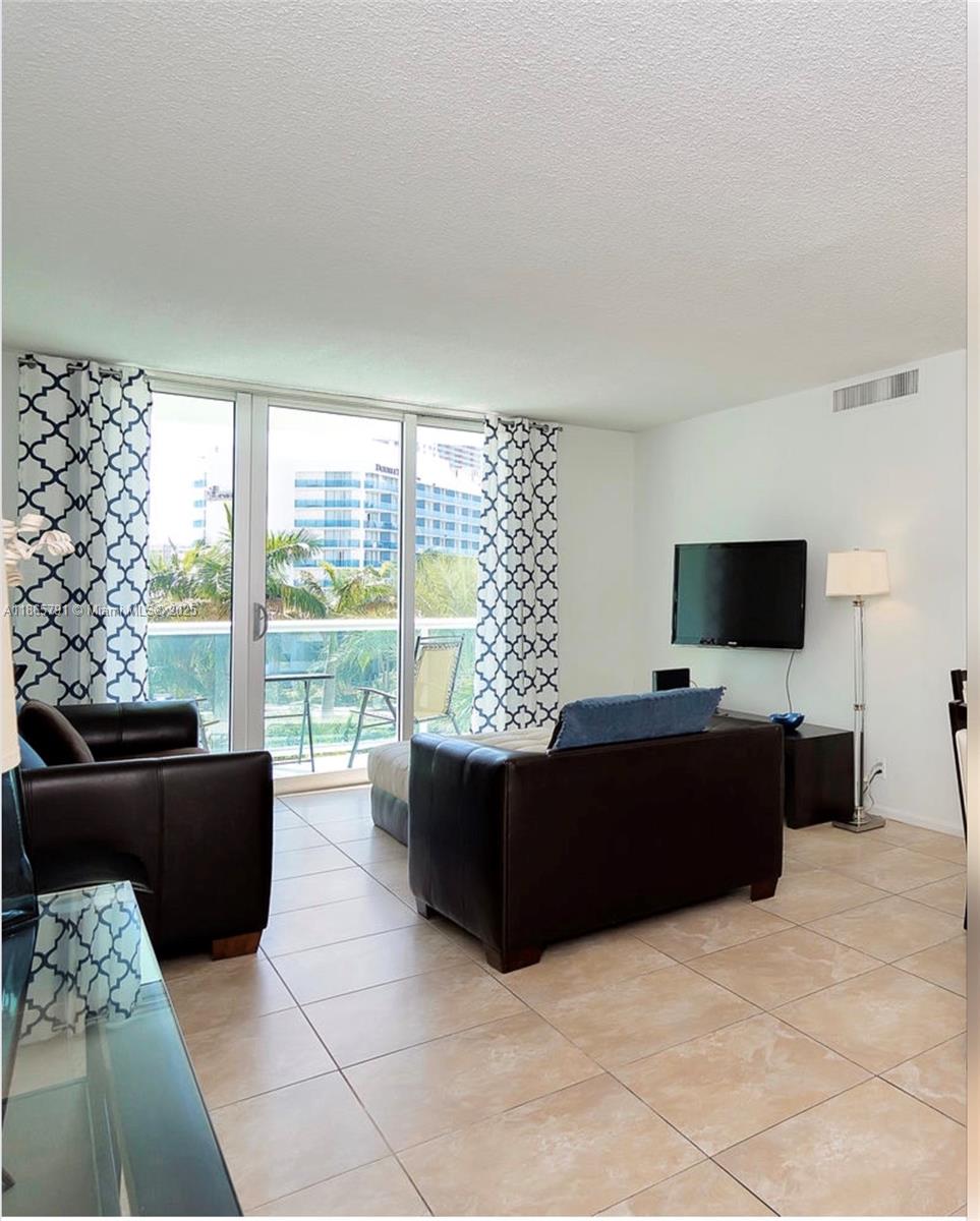 3901 South Ocean Drive, Unit 4U Hollywood, FL 33019 - Photo 2 of 8 a living room with furniture and a flat screen tv