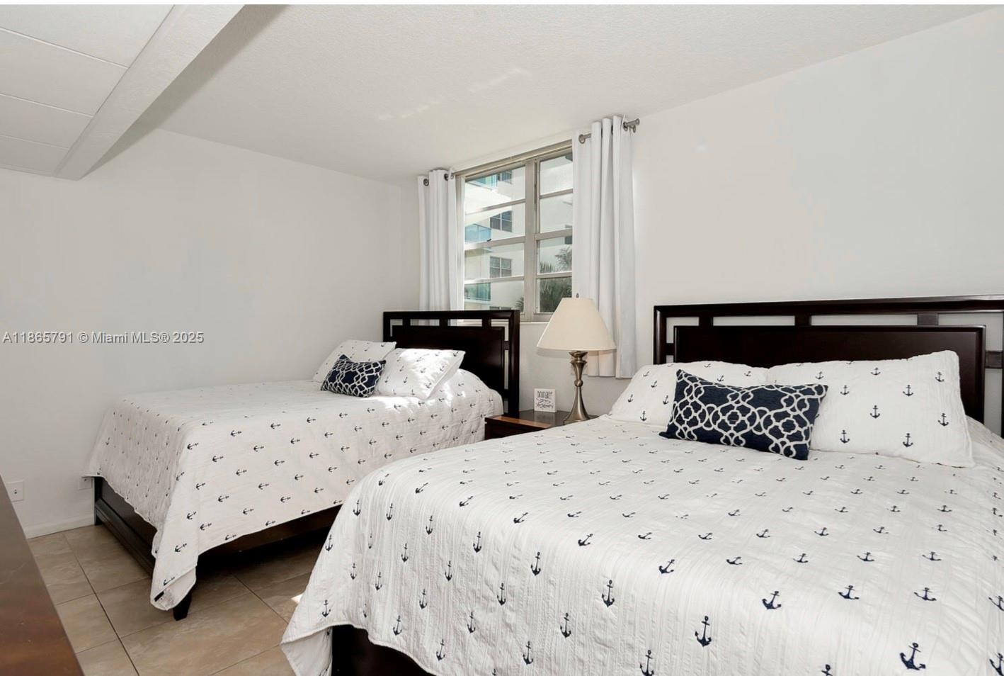 3901 South Ocean Drive, Unit 4U Hollywood, FL 33019 - Photo 7 of 8 a bedroom with two beds and a window