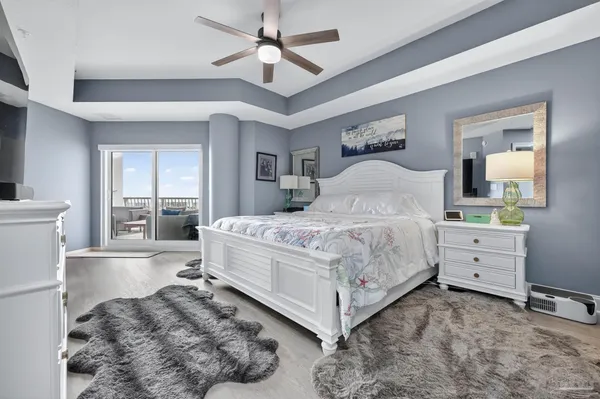 a bedroom with a large bed and a chandelier fan