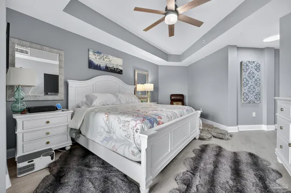 a bedroom with a large bed and a chandelier