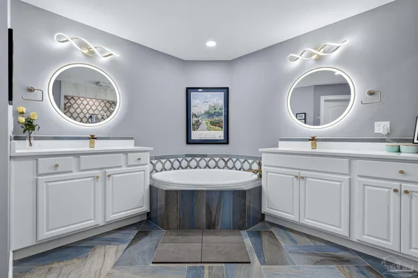 a bathroom with a double vanity sink mirror and bathtub