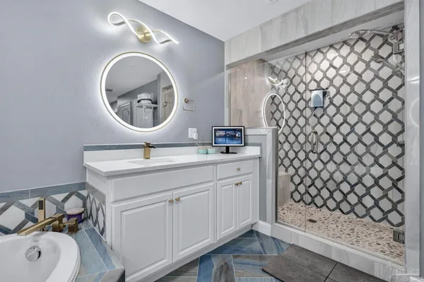 a bathroom with a sink mirror and tub