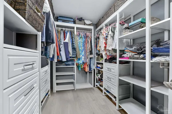 a view of walk in closet with clothes and shoes