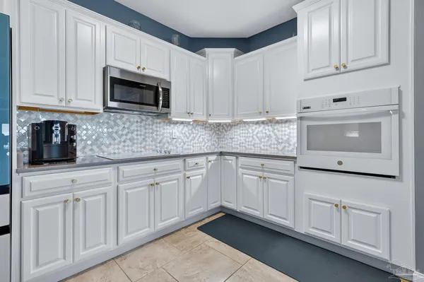 a kitchen with white cabinets and white appliances