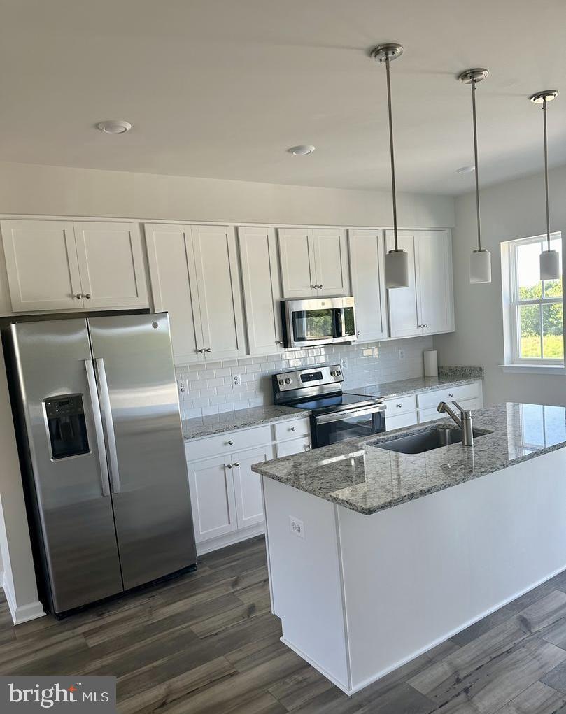149 Swan Fld Avenue Ranson, WV 25438 - Photo 11 of 33 a kitchen with stainless steel appliances granite countertop a refrigerator a sink a stove a microwave and wooden floors