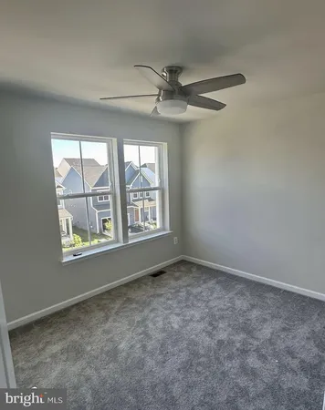 an empty room with windows and fan