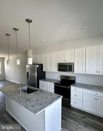 a kitchen with stainless steel appliances granite countertop a sink a stove and a refrigerator